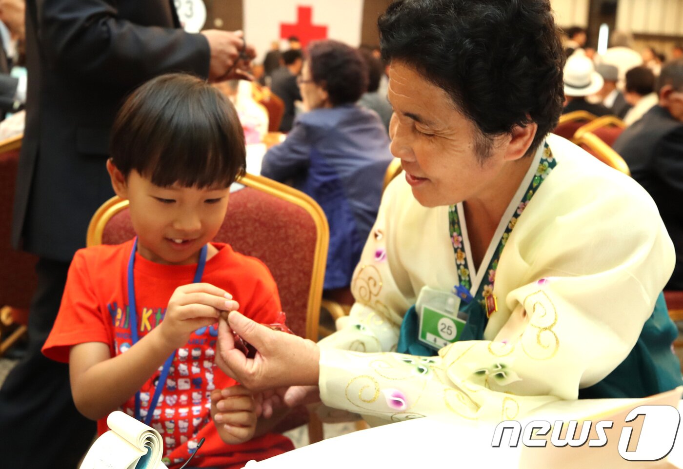 본문 이미지 - 21차 이산가족 상봉행사 2회차 둘째날인 25일 오후 북한 금강산이산가족면회소에서 열린 단체상봉에서 북측 리인숙(84) 할머니가 남측 조카증손자 김연준(7)에게 먹을거를 주고 있다. 2018.8.25/뉴스1 ⓒ News1 뉴스통신취재단