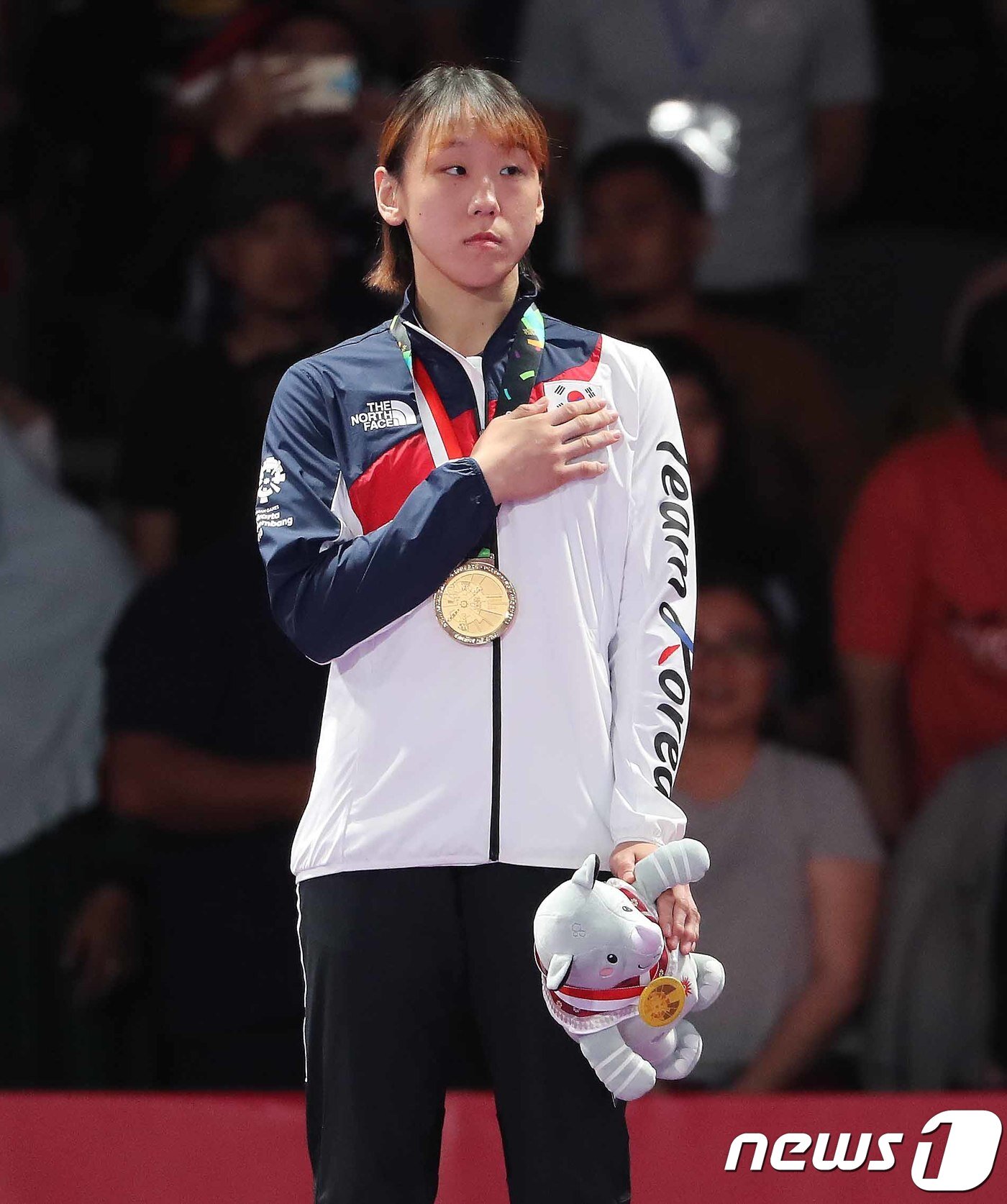 본문 이미지 - 25일 오후 인도네시아 자카르타 컨벤션센터 어셈블리홀에서 열린 2018 자카르타·팔렘방 아시안게임 주짓수 여자 62kg급 금메달 세리머니에서 성기라가 금메달을 목에 걸고 애국가를 듣고 있다. 2018.8.25/뉴스1 ⓒ News1 임세영 기자