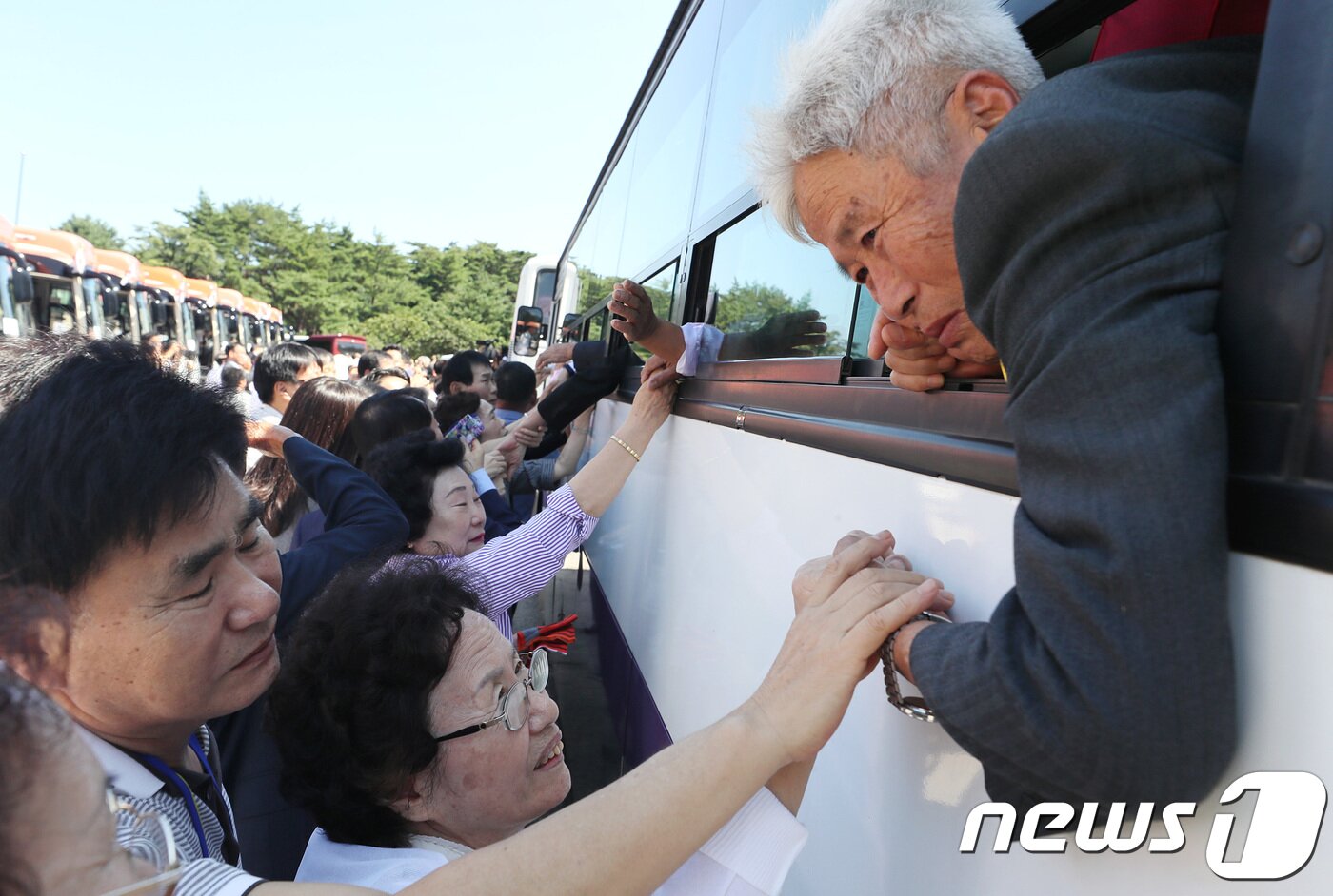 본문 이미지 - 제21차 이산가족 상봉행사 2회차 마지막날인 26일 오후 금강산호텔에서 열린 작별상봉 및 공동중식을 마친 이산가족이 버스 창문 넘어로 작별인사를 하고 있다. 2018.8.26/뉴스1 ⓒ News1 뉴스통신취재단