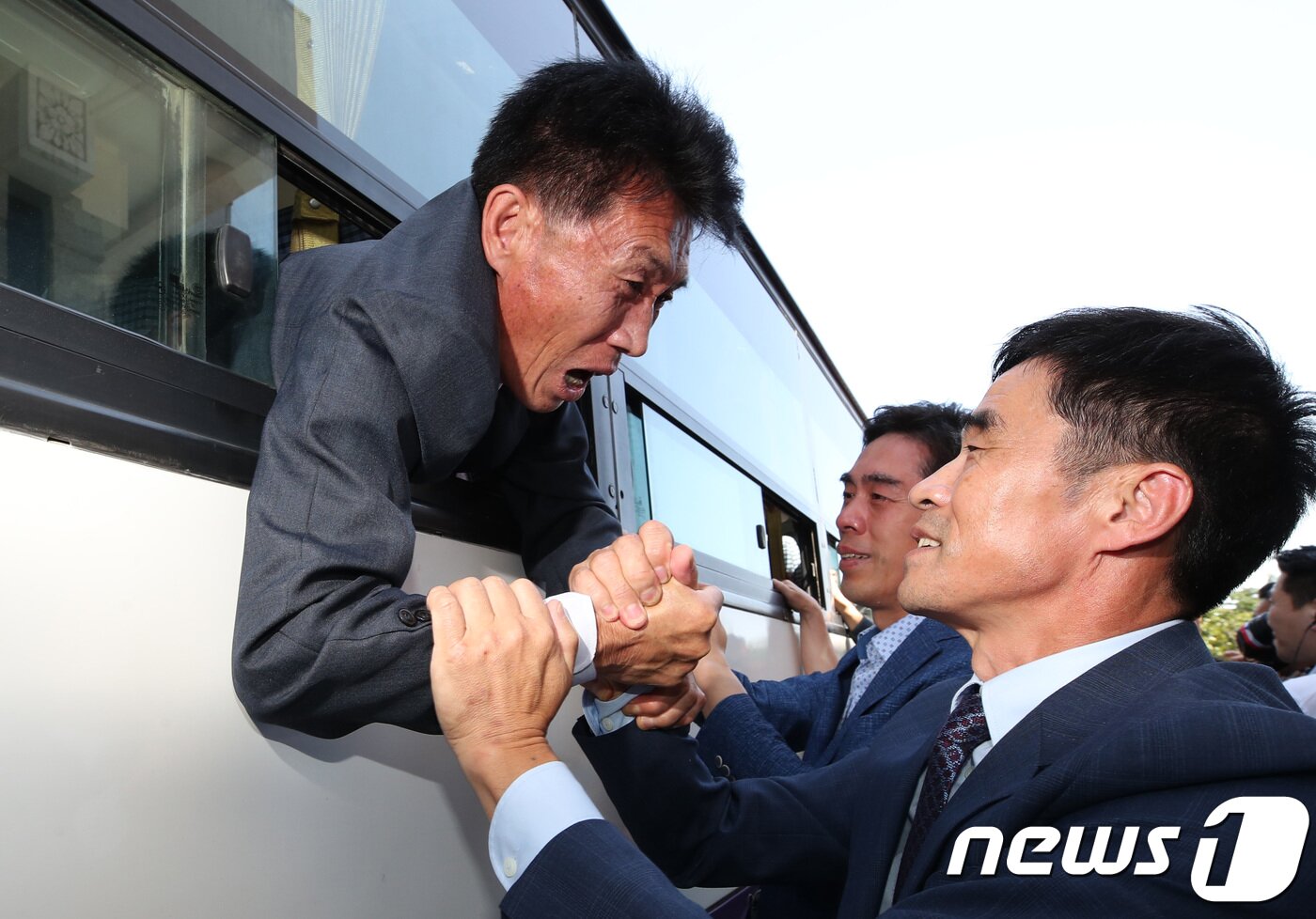 본문 이미지 - 21차 이산가족 상봉행사 2회차 마지막날인 26일 북한 금강산호텔에서 열린 작별상봉 및 공동중식을 마치고 버스에 오른 북측 가족들이 남측 가족들과 헤어지며 눈물을 흘리고 있다. 2018.8.26/뉴스1 ⓒ News1 뉴스통신취재단