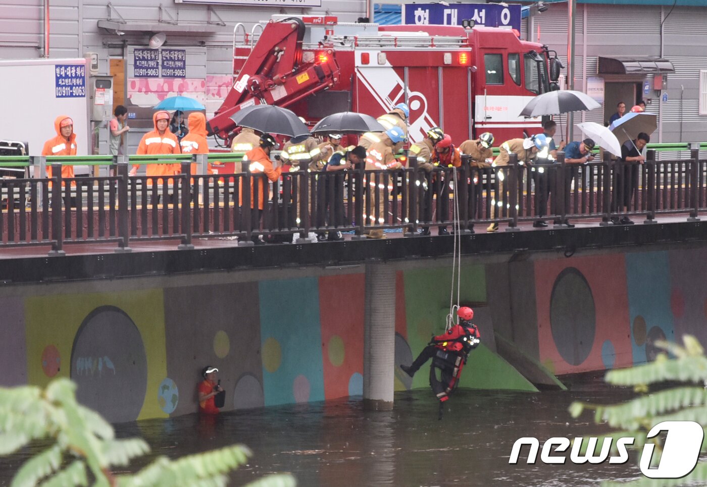 본문 이미지 - 28일 오후 서울 노원구 월계동 우이천에서 노원소방서 대원들이 집중호우로 불어난 물에 의해 고립된 시민을 구조하고 있다. (노원소방서 제공) 2018.8.28/뉴스1 ⓒ News1 송원영 기자