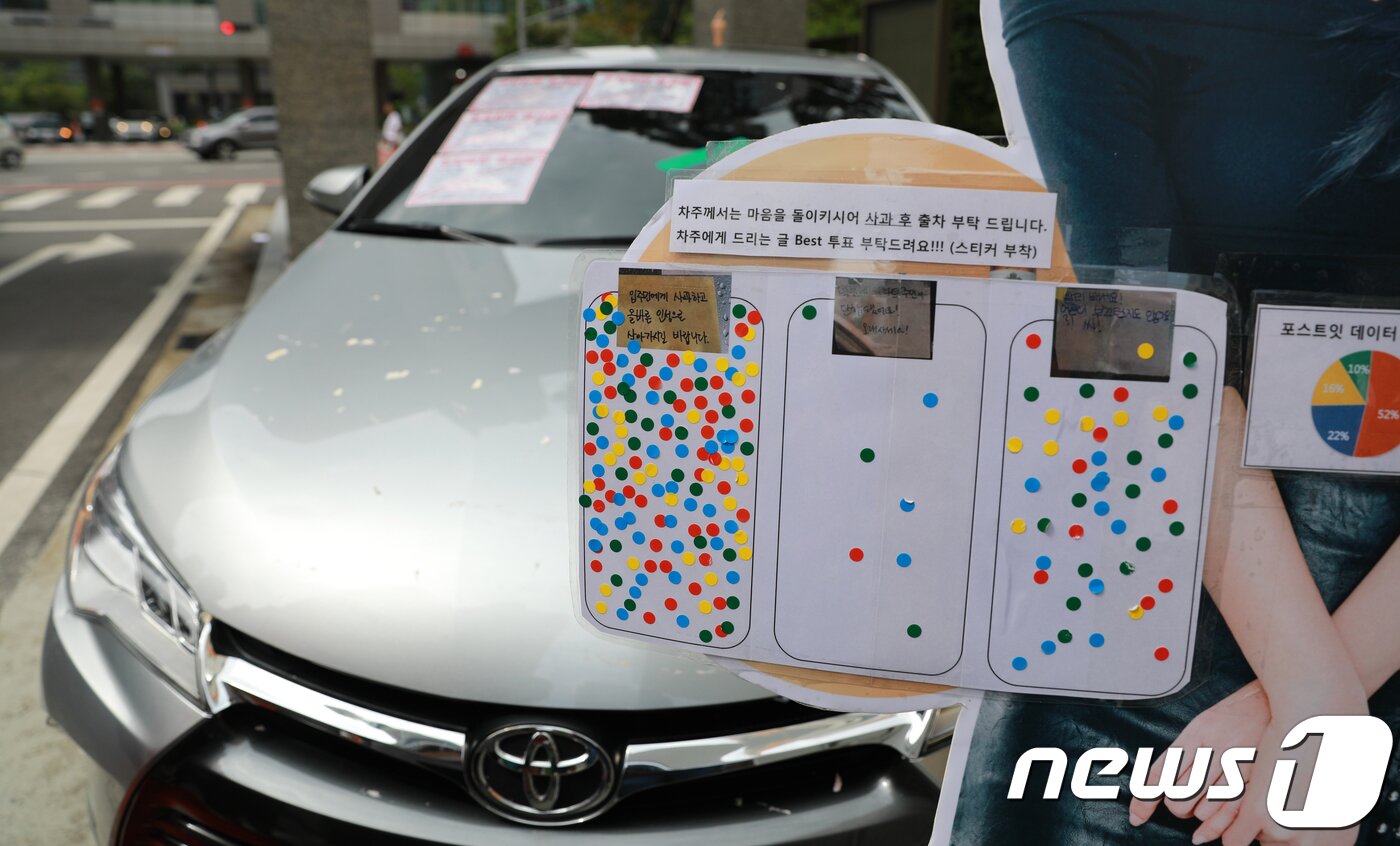 본문 이미지 - 30일 오후 인천시 연수구의 한 아파트단지 정문 인도에 방치된 승용차 옆에 가수 설현의 사진이 인쇄된 입간판이 세워져 있다. 입간판에는 주민 의사를 묻는 설문글과 함께 스티커를 붙일 수 있는 공간도 마련됐다. 차량 주인은 자신의 차량에 주차금지 스티커를 붙인것에 화가나 해당 차량을 아파트 지하주차장 입구에 주차해 주민들의 주차장 이용을 막았다.2018.8.30/뉴스1 ⓒ News1 정진욱 기자