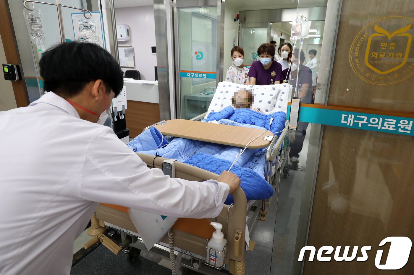 본문 이미지 - 지난 2018년 9월 10일 대구의료원에서 감염관리센터 의료진이 메르스(MERS·중동호흡기증후군) 확산 등 위기상황에 대비하기 위해 음압병실에 있던 환자를 병원 내 지정 장소로 이송하고 있다. 질병관리본부의 지침에 따른 감염병 위기대응 매뉴얼에는 위기시 국가지정 입원치료병상 전체를 대기병상으로 전환하기 위해 4시간 이내에 기존 환자를 다른 병동으로 옮기고 교차오염이 발생하지 않도록 주의하여야 한다./뉴스1 ⓒ News1