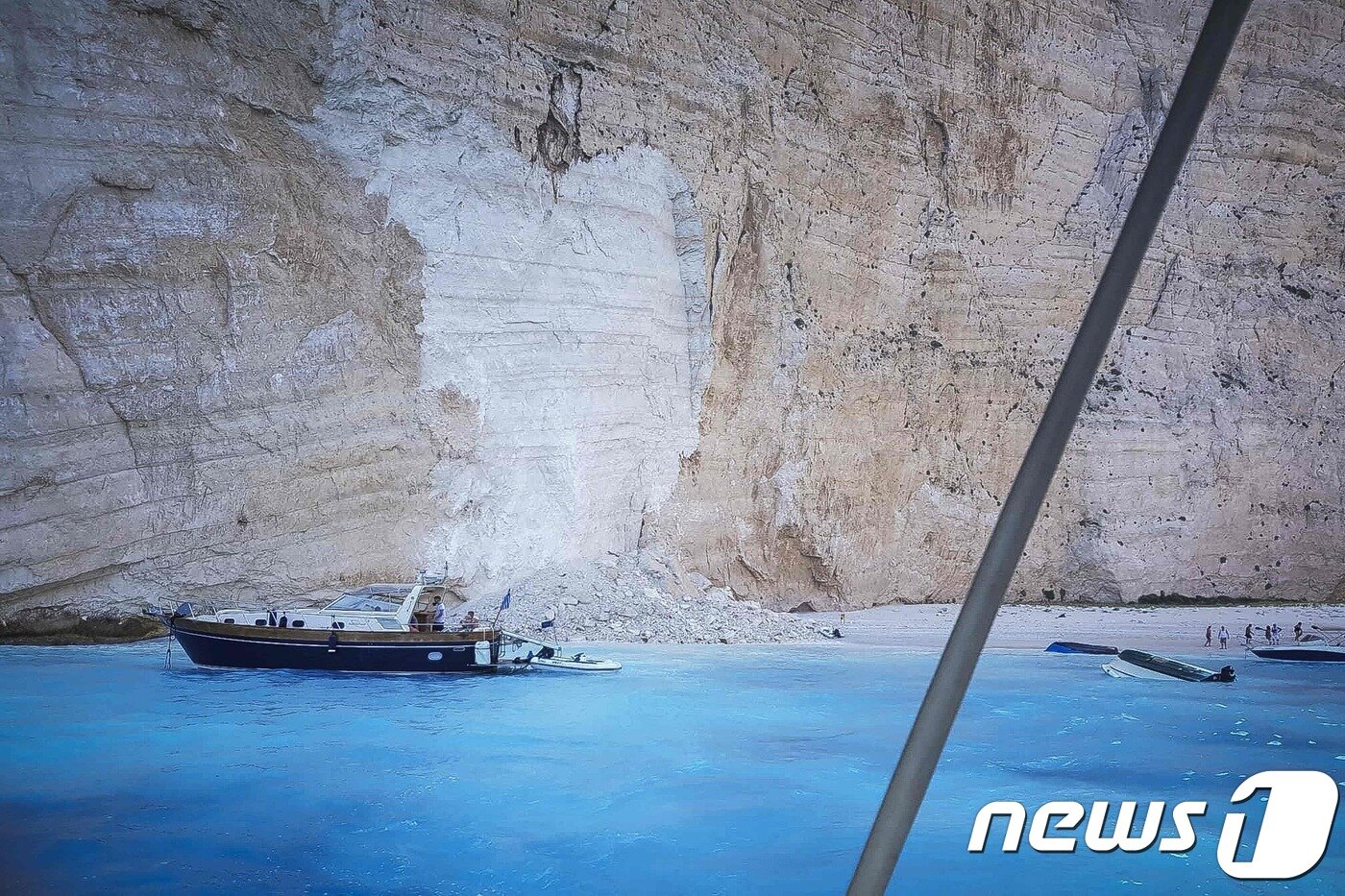 본문 이미지 - 13일(현지시간) 그리스 나바지오 해변에 산사태가 발생해 모래사장에 바위 파편이 떨어진 모습. ⓒ AFP=뉴스1