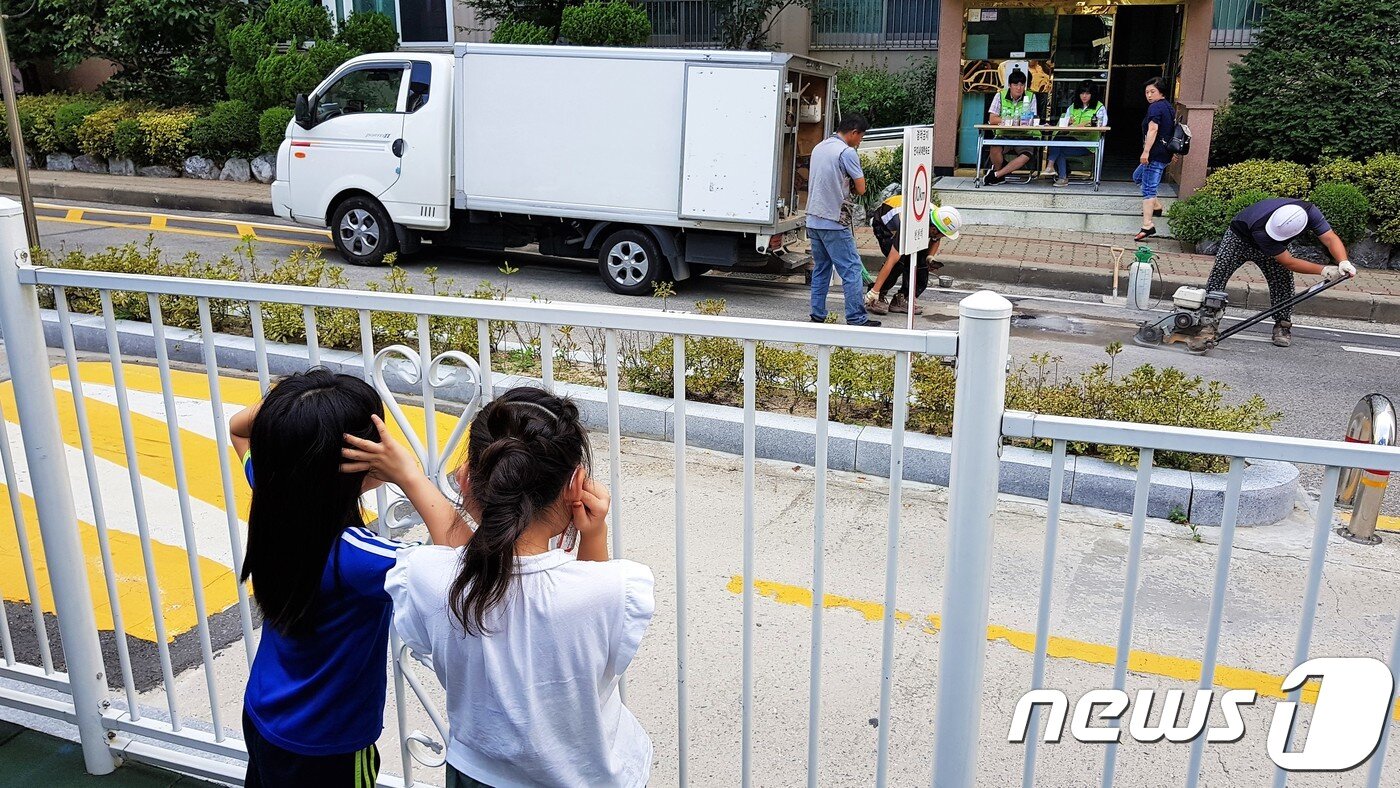 본문 이미지 - 2일 오후 서울 금천구 가산동의 한 아파트 인근 도로에서 관계자들이 지반침하 현상이 발생한 도로를 보강공사하는 가운데 이 아파트에 사는 어린이들이 공사 소음 때문에 귀를 막고 있다. 지난 8월31일 가산동 지상 30층, 지하 3층 규모의 오피스텔 공사장의 맞은편에 위치한 아파트 3개동 주변 도로에서 지반침하 현상이 발생했다. 주민들의 아파트 재입주 가능여부는 2일 오후 5시쯤 발표될 예정이다. 2018.9.2/뉴스1 ⓒ News1 황덕현 기자