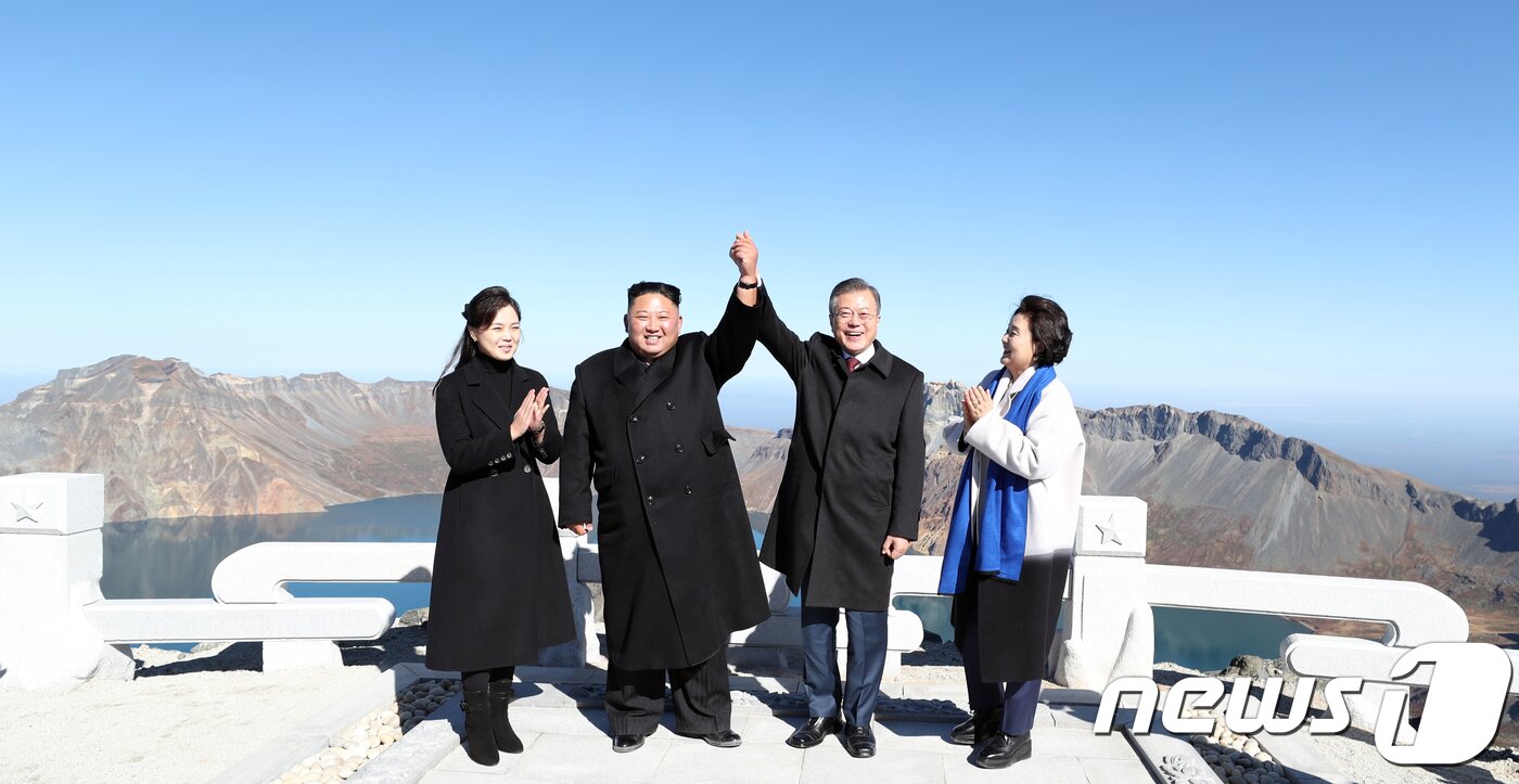 본문 이미지 - 20일 오전 문재인 대통령과 김정은 북한 국무위원장이 백두산 정상인 장군봉에 올라 손을 맞잡아 들어 올리고 있다. 김정숙 여사와 리설주 여사도 함께 했다.2018.9.20/뉴스1 ⓒ News1 평양사진공동취재단