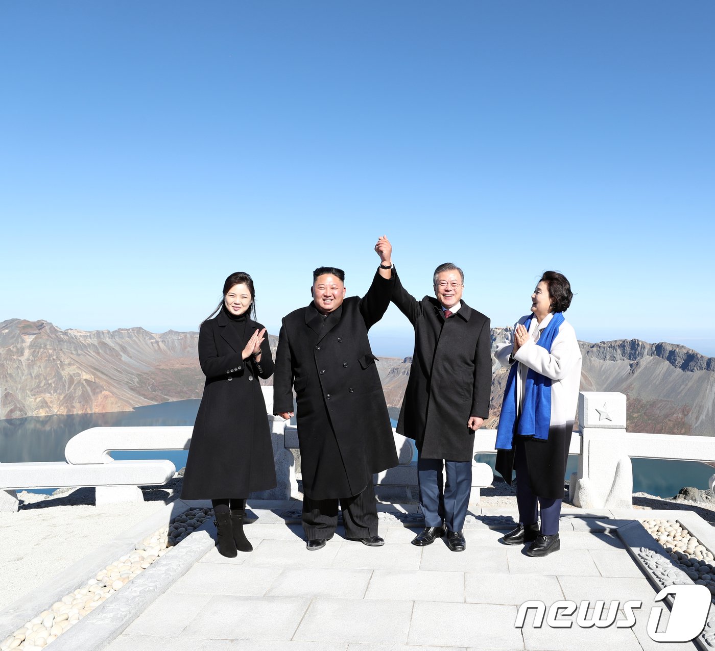 본문 이미지 - 20일 오전 문재인 대통령과 김정은 북한 국무위원장이 백두산 정상인 장군봉에 올라 손을 맞잡아 들어 올리고 있다. 김정숙 여사와 리설주 여사도 함께 했다.2018.9.20/뉴스1 ⓒ News1 평양사진공동취재단