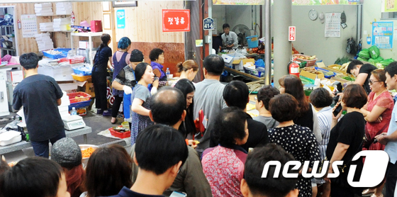 추석을 하루 앞둔 23일 전북의 모든 대형마트가 의무휴업일인 가운데 전주 중앙시장에서 전을 구입하러 온 시민들이 줄을 서고 있다. 2018.9.23/뉴스1 © News1 박슬용 기자