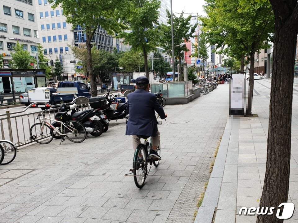 본문 이미지 - 자전거 헬멧을 착용하지 않고 길거리를 다니는 시민들의 모습. ⓒ News1