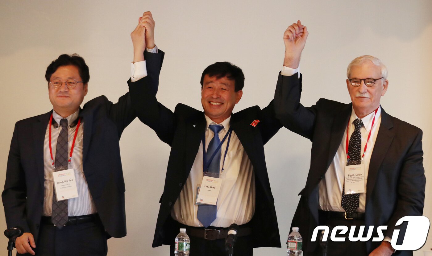 본문 이미지 - 29일(현지시각) 미국 뉴욕 콜롬비아대학에서 열린 ‘2018 국제 평화포럼 : 한반도의 평화와 번영’에서 홍익표(왼쪽부터) 더불어민주당 의원, 리기호 북한 유엔대표부 참사관, 레온 시걸 미국사회과학연구위원회 동북아안보협력프로젝트 국장이 손을 맞잡고 있다.. 2018.9.29/뉴스1 ⓒ News1 특별취재단