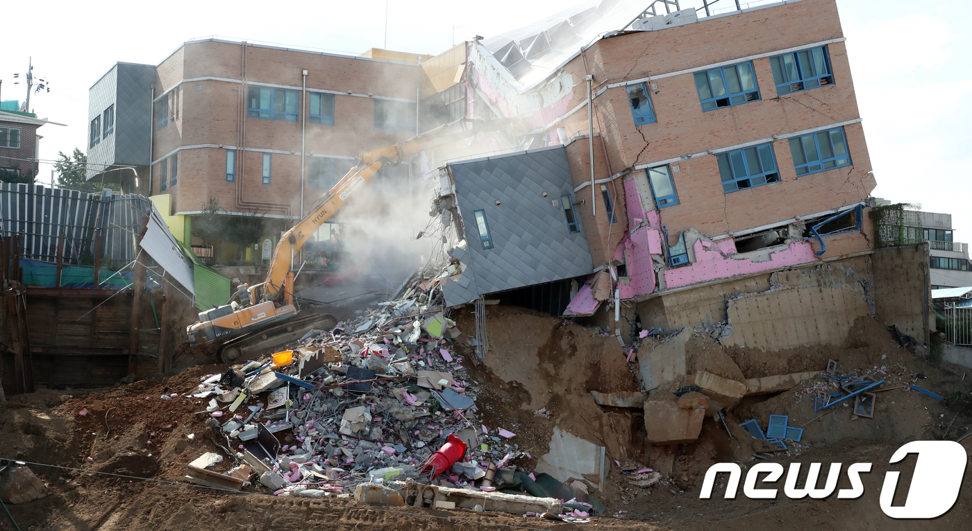 (서울=뉴스1) 황기선 기자 = 9일 오후 서울 동작구 상도유치원 공사장 붕괴현장에서 관계자들이 기울어진 유치원 건물 철거 작업을 하고 있다.동작구청은 이날 오후 유치원 건물 철거 …
