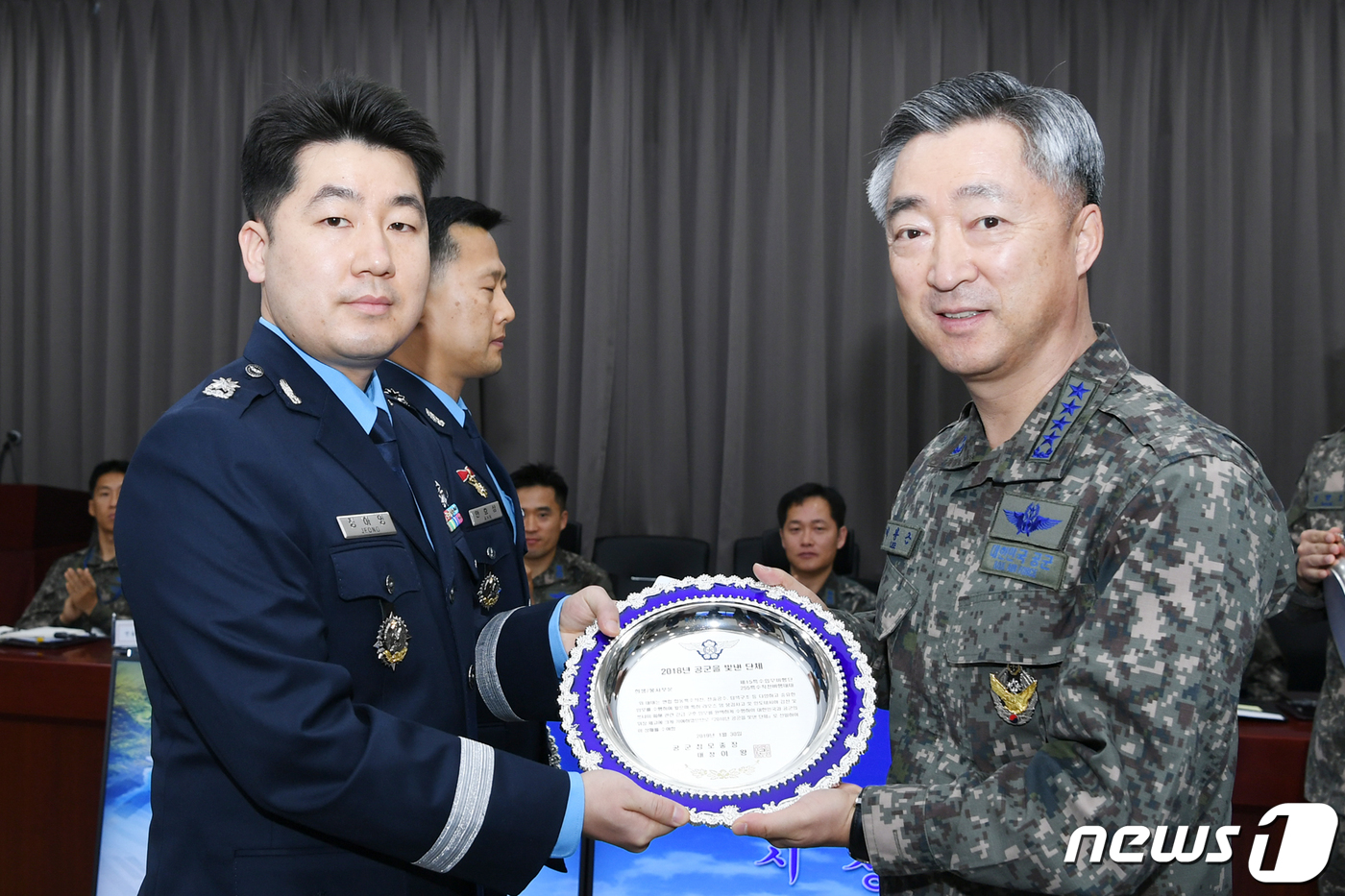 (서울=뉴스1) = 30일 오전 공중기동정찰사령부에서 열린 '2018년 공군을 빛낸 인물시상식'에서 이왕근 공군참모총장(오른쪽)이 희생·봉사 부문 수상자인 15특수임무비행단 255 …