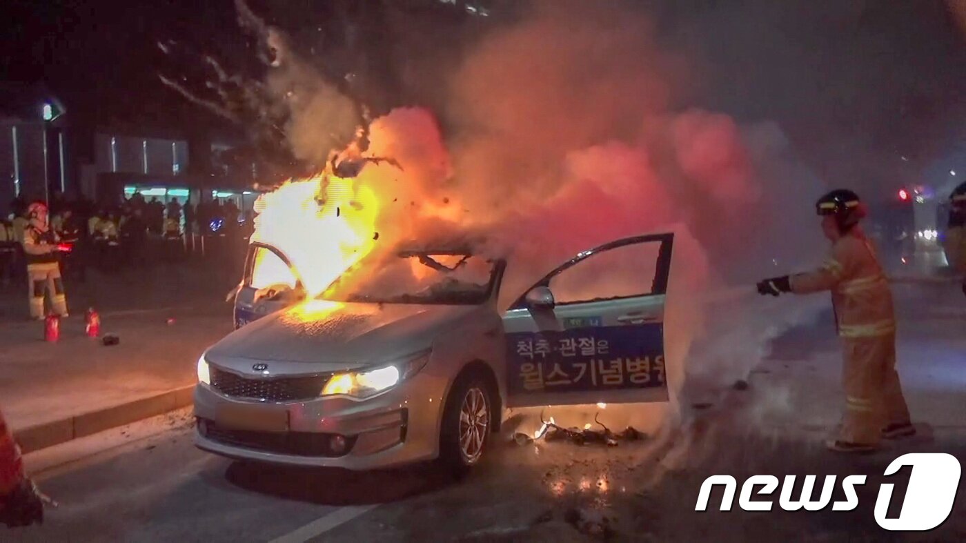 본문 이미지 - 9일 오후 6시3분경 서울 종로구 세종대로에서 택시에 화재가 발생해 소방대원들이 불을 끄고 있다. 소방당국과 목격자에 따르면 '경기' 차량 번호판을 단 은색 K5 승용차에 불이 났고, 이 불은 출동한 소방대원에 의해 약 6분 만에 완전히 진화됐다. 이 화재로 운전기사 임모씨(65·남)가 2도 화상을 입고 병원으로 옮겨졌다. (종로소방서 제공) 2019.1.9/뉴스1