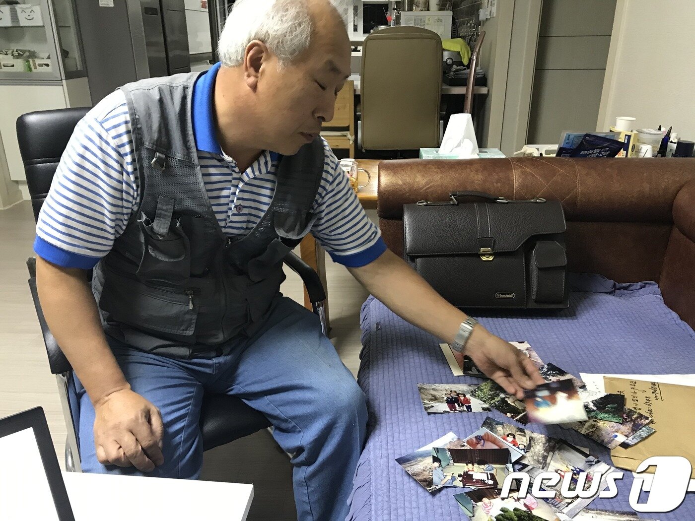 본문 이미지 - 조병세씨(58)가 무거운 한숨을 쉬며 실종된 딸 조하늘양 모습이 담긴 사진들을 하나씩 보고 있다. ⓒ 뉴스1 박혜연 기자