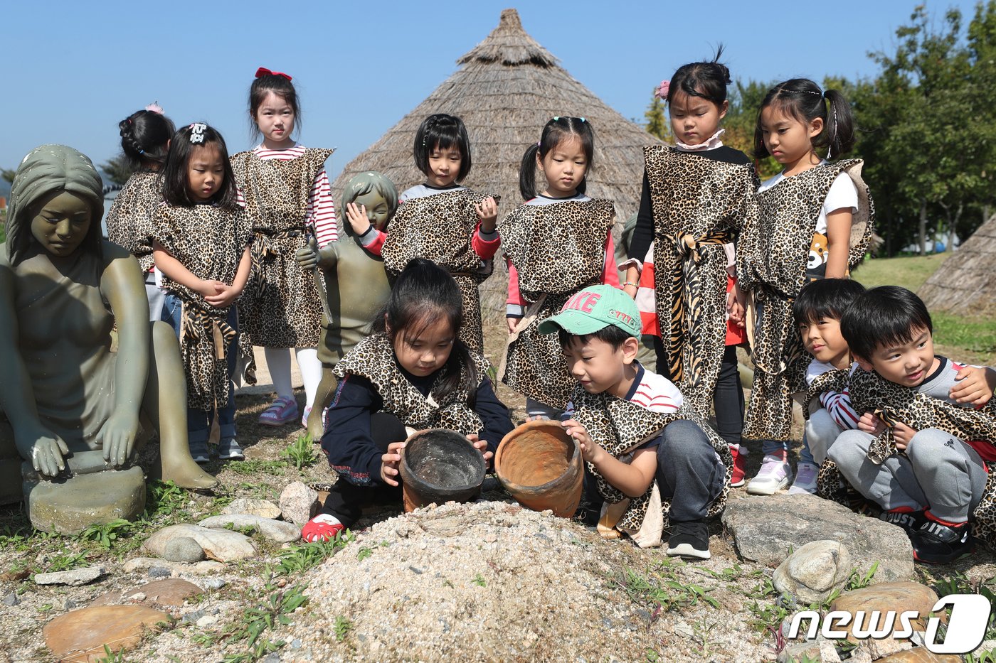 본문 이미지 - 11일 서울 강동구 암사동 선사유적지 움집터에서 원시인 복장의 어린이들이 '어린이 신석기 고고학 체험스쿨'에 참여해 선사시대 생활상 체험을 하고 있다. 2019.10.11/뉴스1 ⓒ News1 민경석 기자