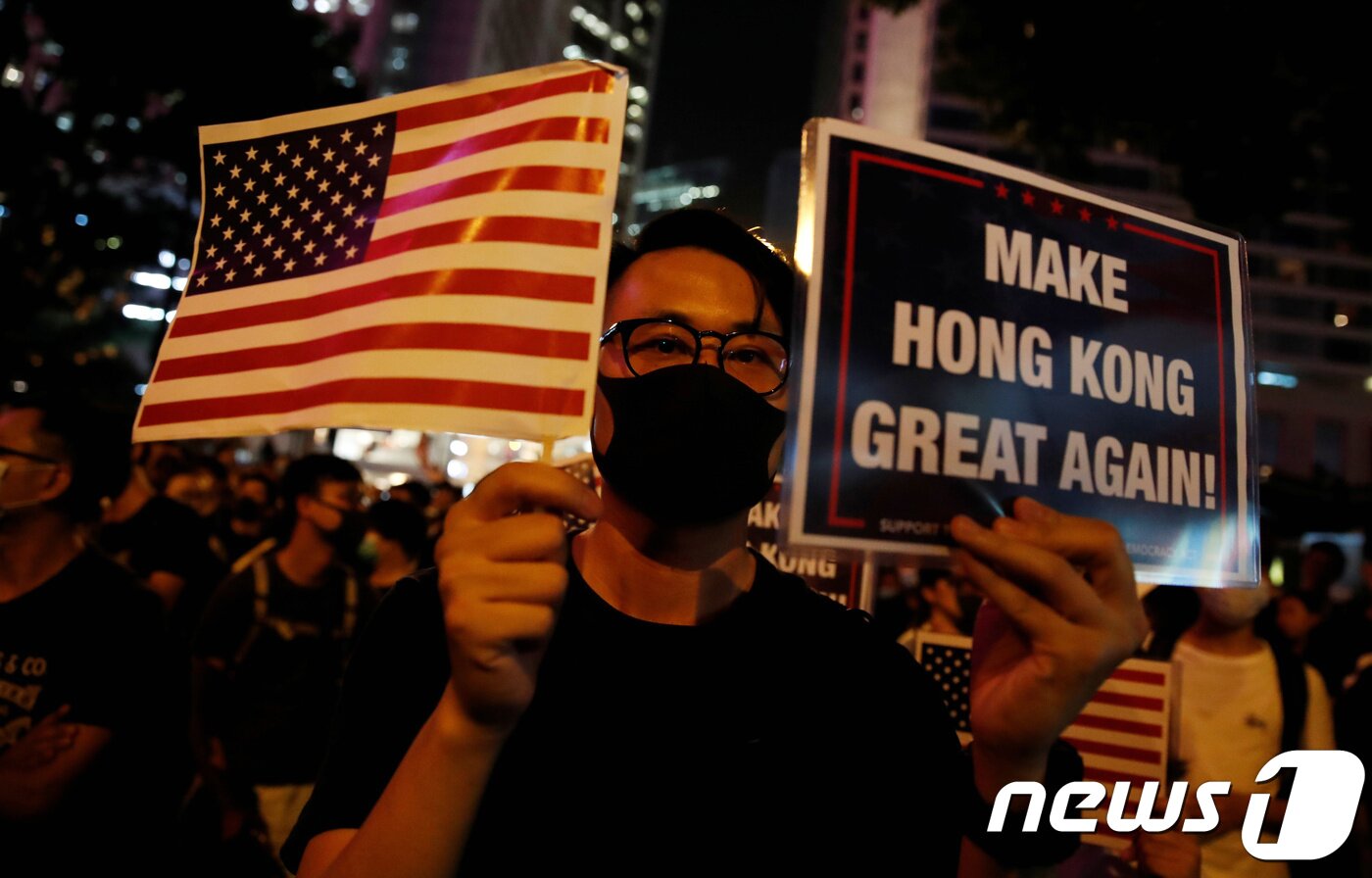 본문 이미지 - 한 시위 참가자가 성조기와 트럼프 대통령의 선거 구호를 흉내낸 '홍콩을 다시 위대하게' 팻말을 들고 있다. ⓒ 로이터=뉴스1 ⓒ News1 