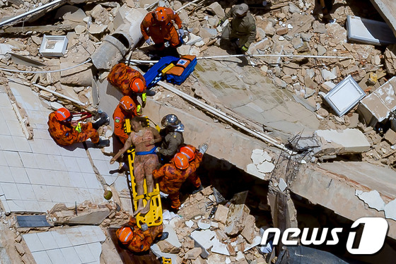 브라질 북동부 포르탈레자시에서 15일(현지시간) 7층짜리 건물이 붕괴되는 사고가 발생했다. 사진은 건물 붕괴 현장에서 생존자가 구조되는 모습. © AFP=뉴스1
