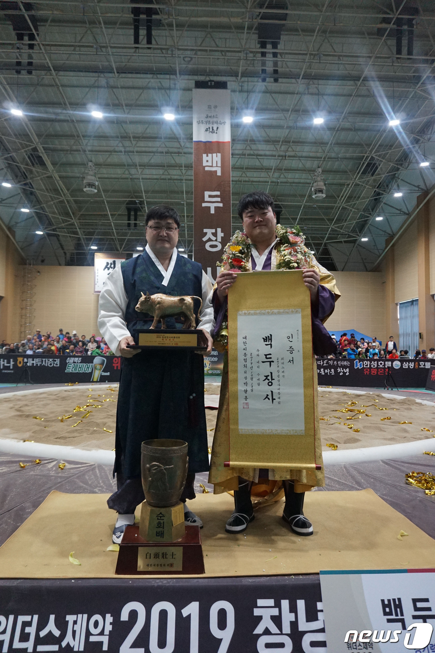 (서울=뉴스1) = 19일 경남 창녕국민체육센터에서 열린 '위더스제약 2019 창녕장사 씨름대회'에서 백두장사에 오른 김찬영(연수구청)이 한대호 감독과 기념촬영을 하고 있다. (대 …