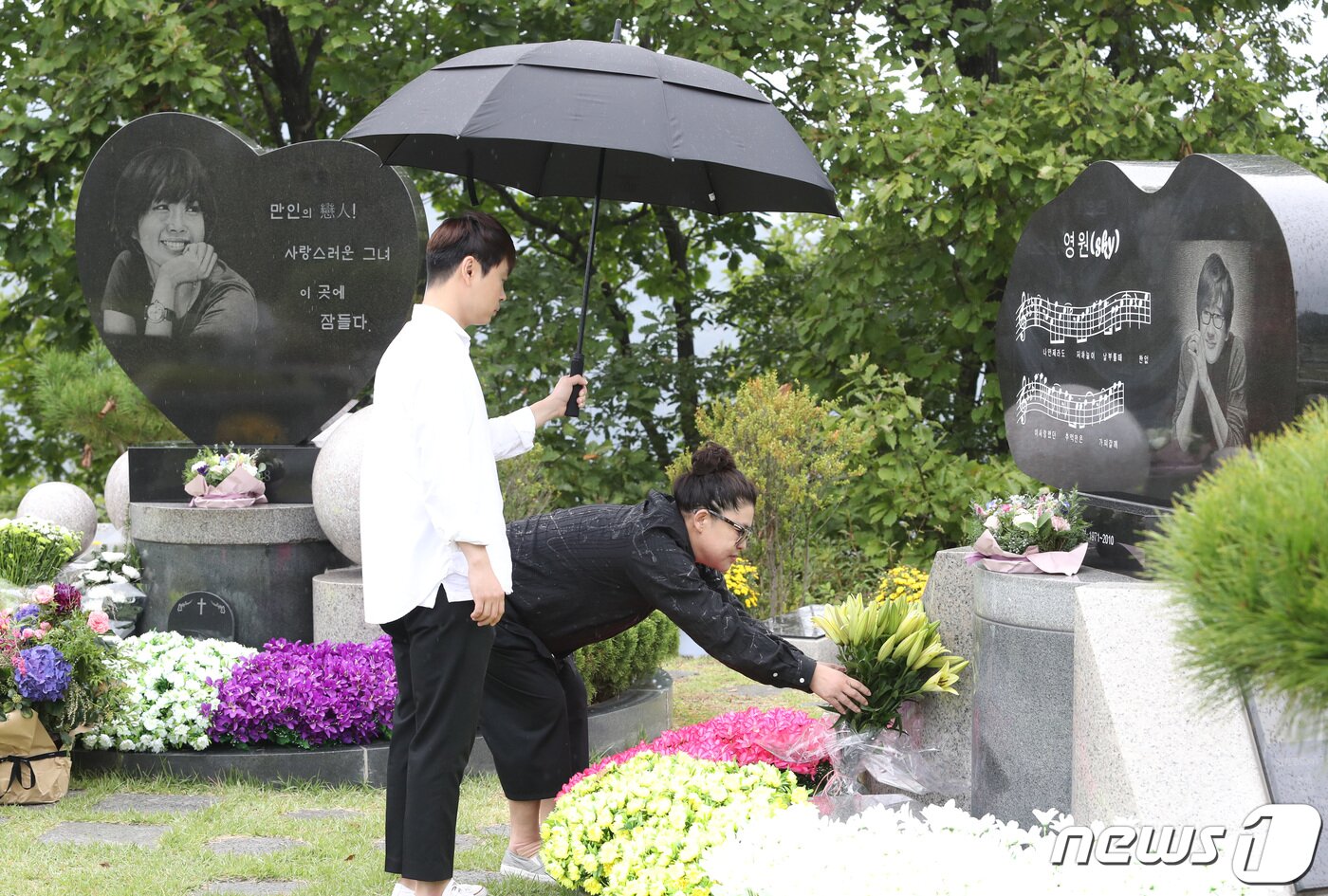 본문 이미지 - 2일 오전 경기도 양평군 갑산공원묘역에서 열린 故 최진실의 11주기 추도예배에 참석한 방송인 이영자와 송성호 매니저(왼쪽)가 고인 동생 최진영 묘소에 꽃을 놓고 있다. 2019.10.2./뉴1 ⓒ News1 권현진 기자