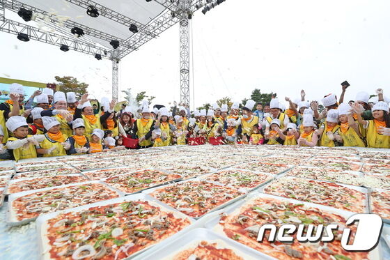 6일 전북 임실군에서 열린 2019 임실N치즈축제 일환으로 열린 ‘국가대표 왕피자 만들기’에 수많은 어린이와 부모들이 참여해 피자를 만들고 있다.(임실군 제공)2019.10.6/뉴스1 © News1 이정민 기자