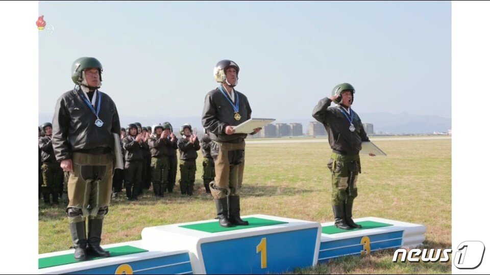 본문 이미지 - 북한 노동당 기관지 노동신문은 16일, 김정은 위원장이 원산갈마비행장에서 "조선인민군 항공 및 반항공군 비행지휘성원들의 전투비행술경기대회-2019를 참관했다"고 밝혔다. 대회 뒤 시상식이 열리고 있다 (조선중앙TV 캡처화면) ⓒ 뉴스1