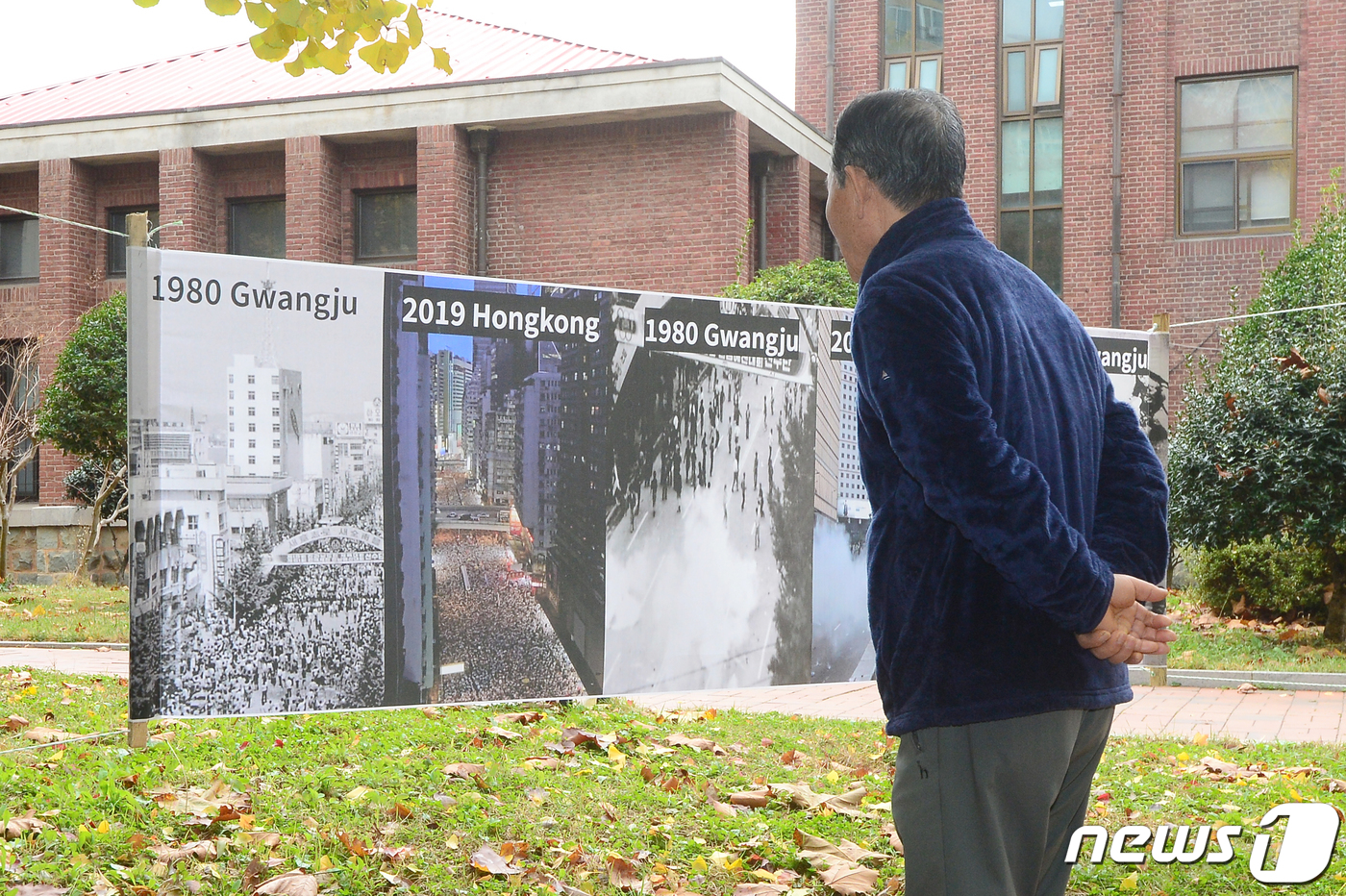 (광주=뉴스1) 한산 기자 = 18일 오전 광주 북구 전남대학교에서 한 시민이 1980년 광주민주화운동 당시 모습과 5달째 이어지고 있는 홍콩 시위 모습을 함께 담은 현수막을 바라 …