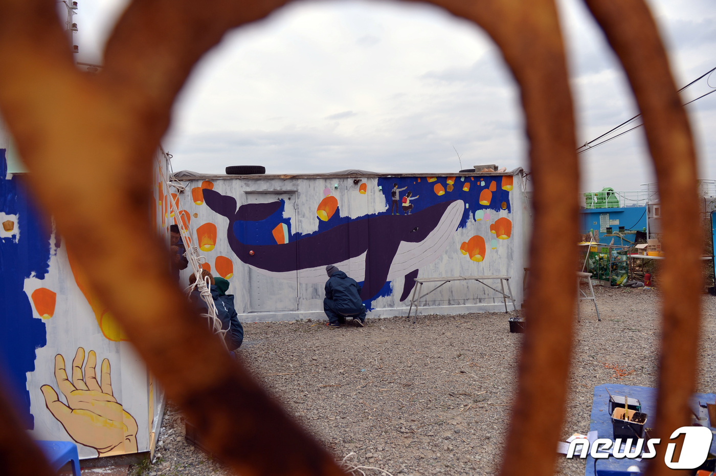 (진도=뉴스1) 박준배 기자 = 세월호 광주시민상주모임 회원들과 행동예술장 작가들이 30일 오후 전남 진도군 팽목항 세월호 가족 식당과 창고 건물 외벽에 '세월호 고래'와 '소원을 …