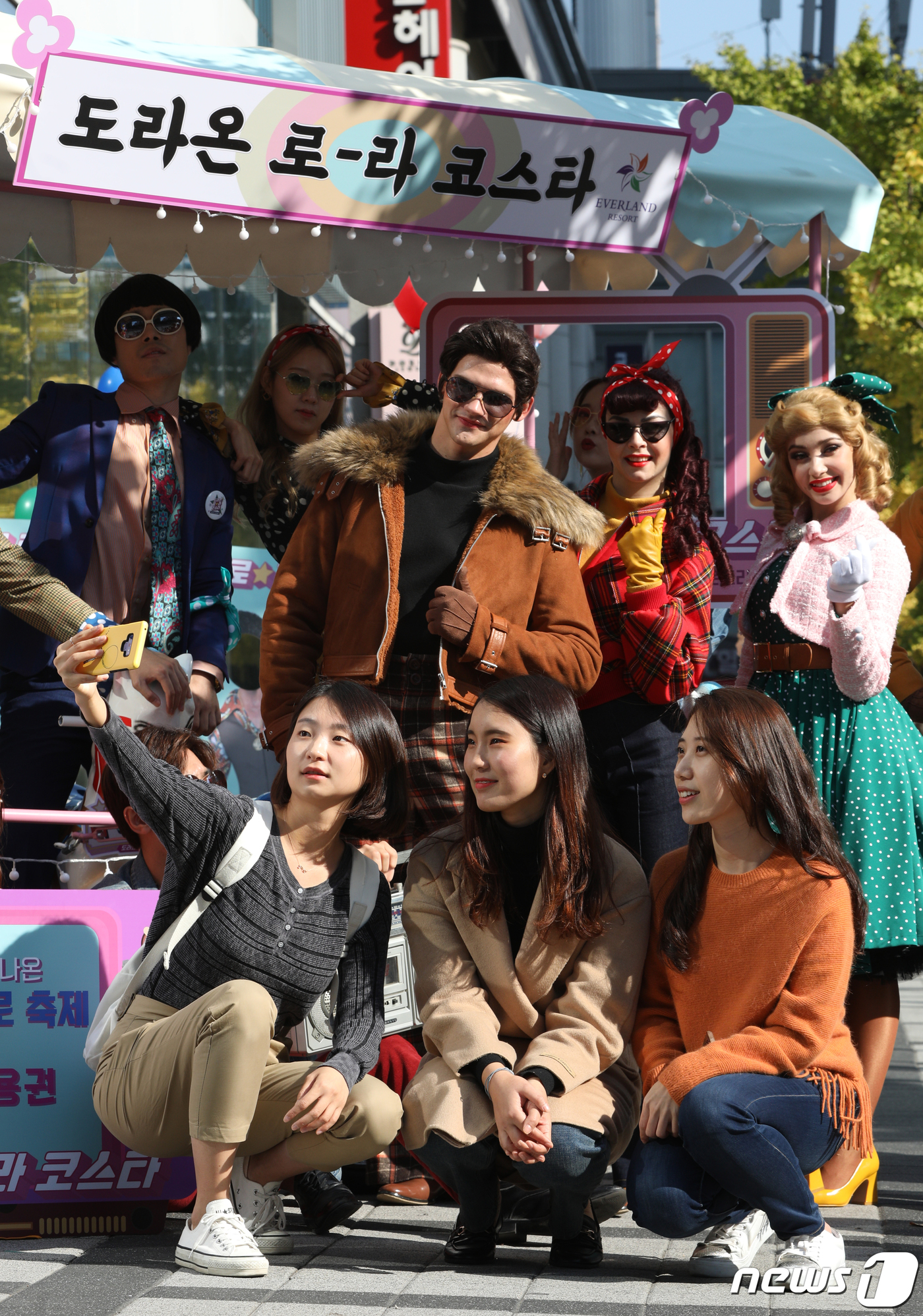 (서울=뉴스1) 신웅수 기자 = 7일 오전 서울 마포구 삼성디지털프라자 홍대점 앞에서 시민들이 복고풍 복장을 한 모델들과 기념촬영을 하고 있다.삼성물산 리조트부문이 운영하는 에버랜 …