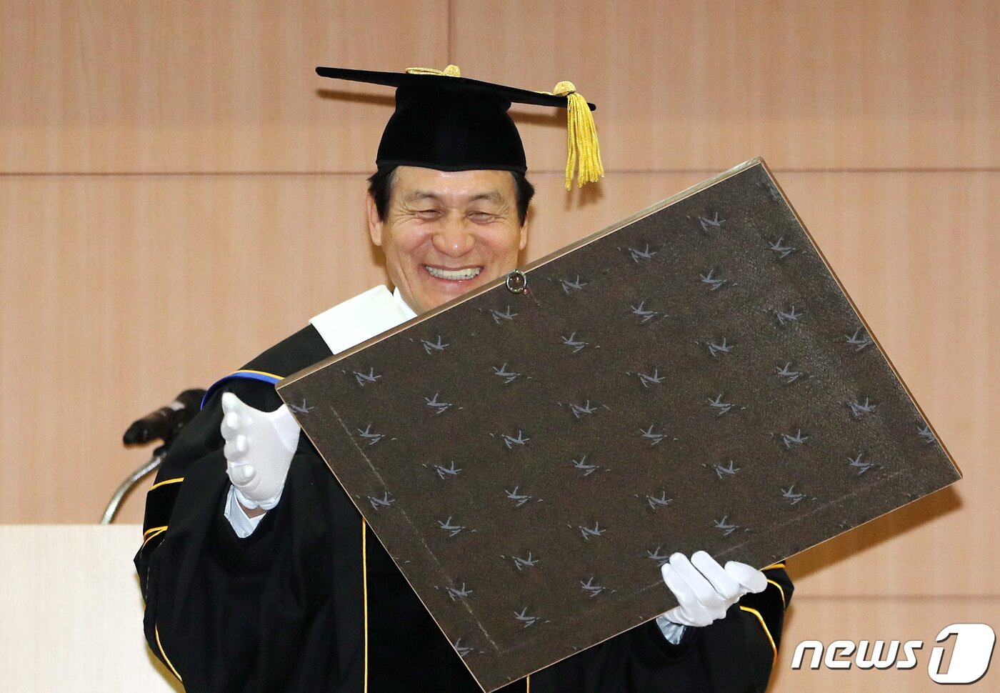 본문 이미지 - 영화배우 안성기가 지난 2019년 경기도 수원시 경기대학교 수원캠퍼스에서 열린 명예문화박사 학위수여식에 참석해 기념패를 보며 미소짓고 있다. 2019.11.7/뉴스1 ⓒ News1  