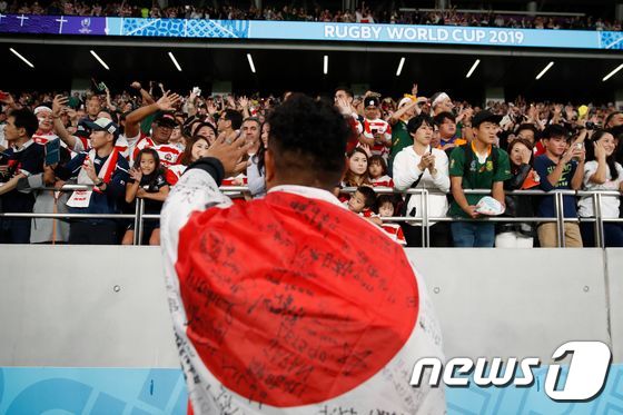 일본 도쿄 스타디움에서 열린 2019 럭비 월드컵에서 한 선수가 일본 국기를 몸에 감은 채 관객들에게 인사를 하고 있다. © AFP=뉴스1