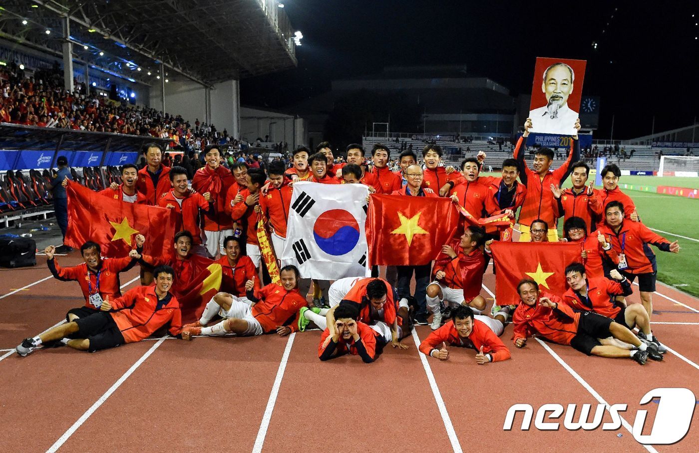 본문 이미지 - 10일 (현지시간) 박항서 감독이 이끄는 베트남 22세 이하 축구대표팀이 마닐라에서 열린 동남아시안게임에서 인도네시아를 꺾고 60년 만의 우승을 한 뒤 선수들이 태극기와 베트남의 국기인 금성홍기를 함께 들고 기뻐하고 있다. ⓒ AFP=뉴스1 ⓒ News1 우동명 기자