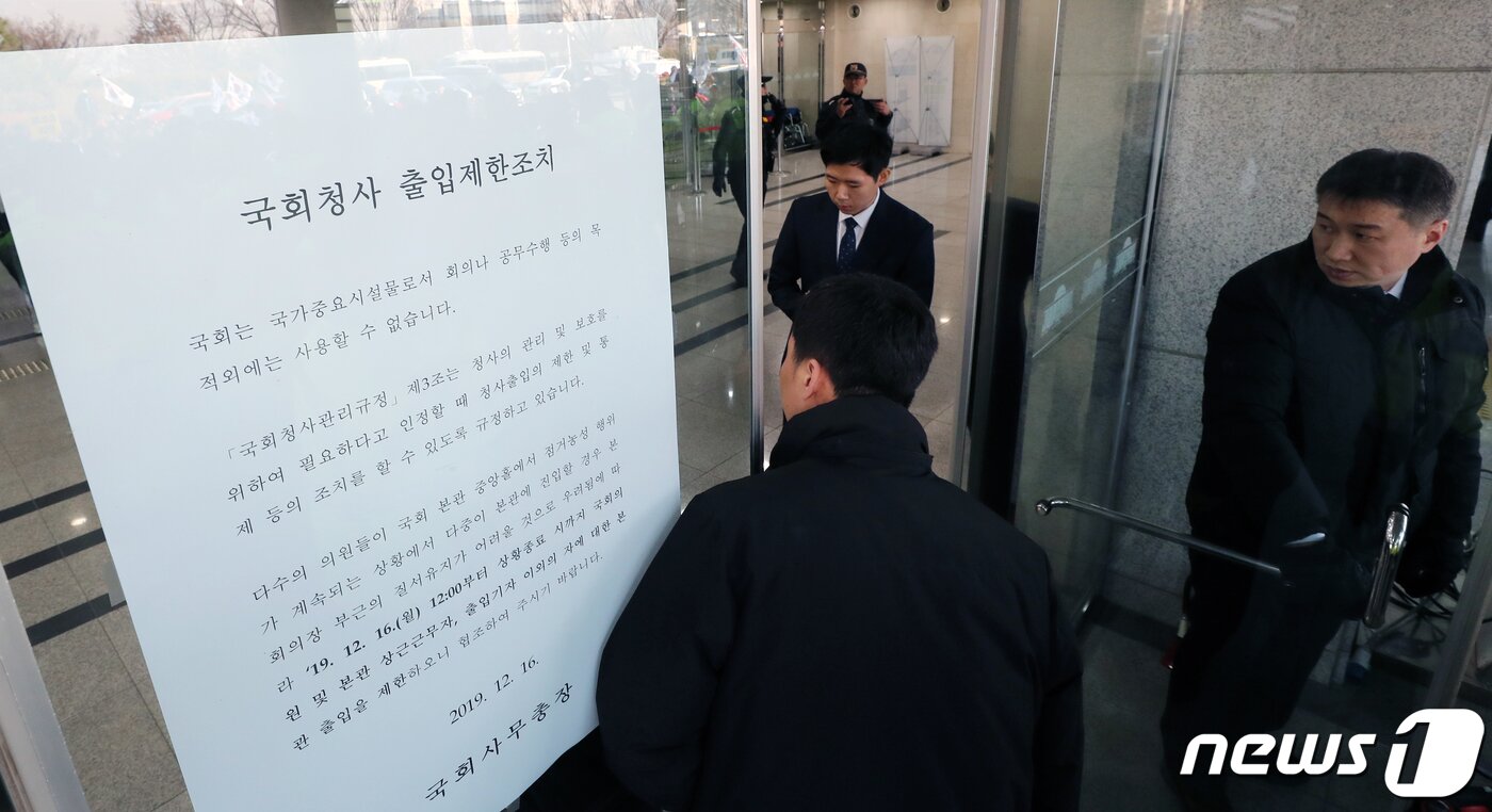 본문 이미지 - 국회 경위들이 지난 16일 서울 여의도 국회 본청 출입문을 막고 '국회청사 출입제한조치'를 시행하고 있다. 이날 보수단체 회원들이 자유한국당의 '공수처법 선거법 날치기 저지 규탄대회'중 국회 본청 진입을 시도해 '국회청사 출입제한조치'가 발동됐다. 2019.12.16/뉴스1 ⓒ News1 이종덕 기자