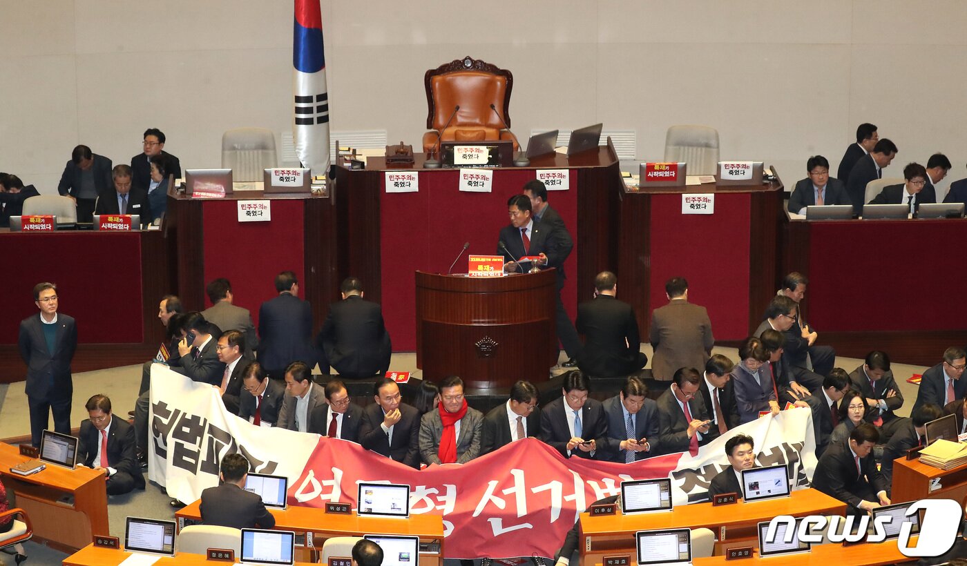 본문 이미지 - 자유한국당 의원들이 27일 서울 여의도 국회 본회의장에서 제373회 국회(임시회) 제1차 본회의 개의를 막기위해 의장석을 둘러싸고 있다. 이날 국회에서는 선거법이 표결에 붙여질 예정이다. 2019.12.27/뉴스1 ⓒ News1 임세영 기자