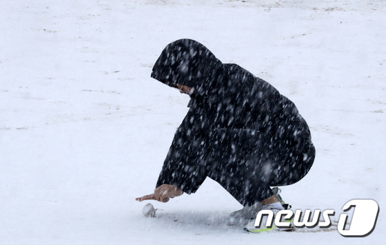 경기 일부 지역에 눈이 내린 3일 오전 군포시 산본고등학교에서 한 학생이 운동장에 쌓인 눈을 굴리고 있다. 2019.12.3/뉴스1 © News1 조태형 기자