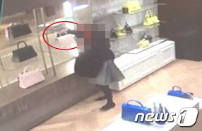 A씨가 백화점 명품관에서 손님인 척 가방을 구경하는 모습.(부산지방경찰청 제공)© 뉴스1