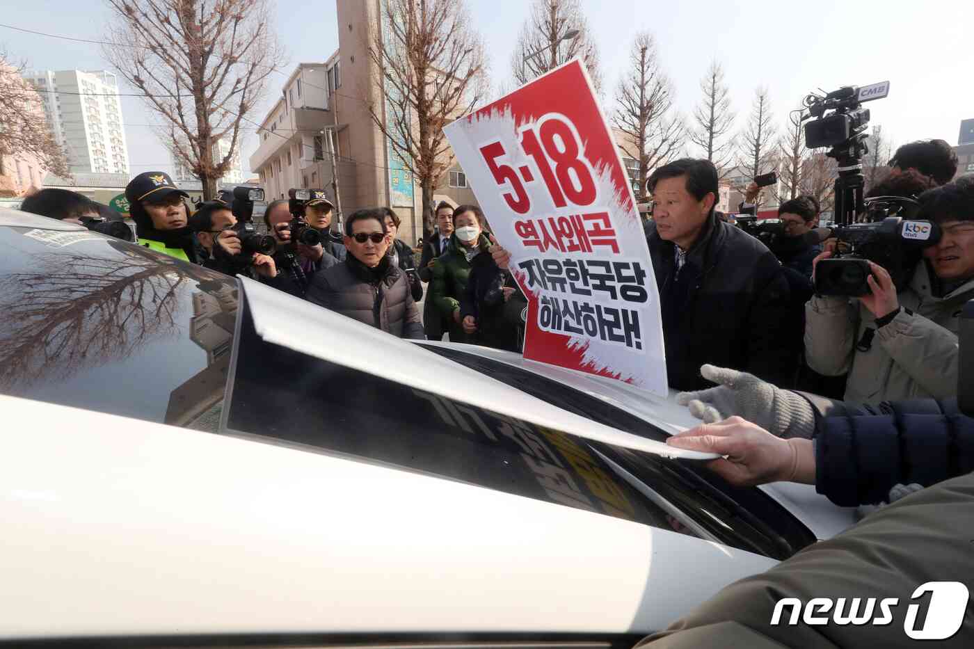 12일 오전 광주 북구 자유한국당 광주시당에서 열린 당원 간담회에 김진태 의원의 참석 소식을 접한 광주 시민단체 회원들이 김 의원이 탄 것으로 보이는 한 차량 앞에서 피켓을 들고 항의를 하고 있다. 김 의원은 지난 8일 '5·18 망언'이 쏟아진 국회 공청회를 공동 주최했으며, 이날 간담회를 마친 뒤 차량으로 복귀하는 과정에서 광주 시민의 거센 항의를 받기도 했다. 2019.2.12/뉴스1 © News1 황희규 기자