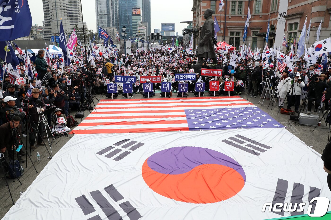 본문 이미지 - 박근혜 전 대통령 탄핵 2년을 맞은 10일 오후 서울역 광장에서 열린 '제113차 태극기 집회'에서 박근혜대통령 무죄 석방 1천만 국민운동본부와 대한애국당 등 참석자들이 손팻말과 태극기를 들고 구호를 외치고 있다. 2019.3.10/뉴스1 ⓒ News1 황기선 기자