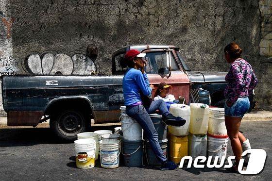 13일(현지시간) 6일 동안 대규모 정전사태로 급수가 중단되자 베네수엘라 카라카스의 주민들이 아빌라 국립공원에서 물을 받기위해 물통을 쌓아놓고 있다. © AFP=뉴스1 © News1 우동명 기자