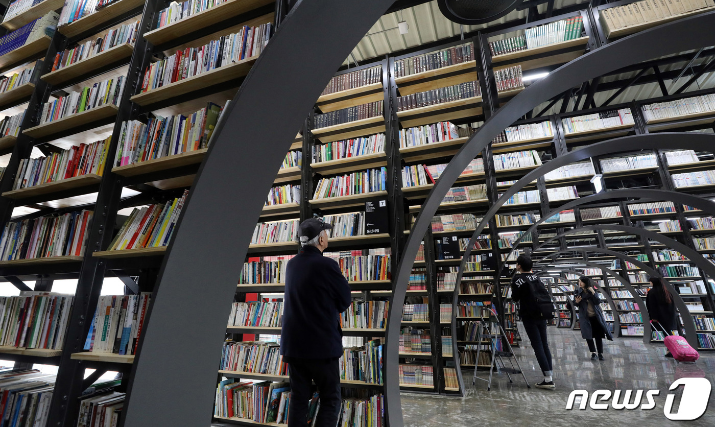 (서울=뉴스1) 이재명 기자 = 27일 오후 서울 송파구 신천 유수지 내 창고에 위치한 헌책방 '서울책보고'를 찾은 시민들이 책을 고르고 있다.서울책보고는 단순한 헌책 판매처가 아 …