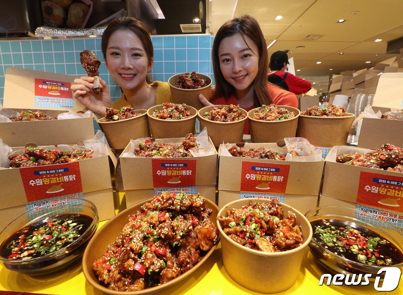 본문 이미지 - 서울 중구 롯데백화점 본점에서 모델들이 수원왕갈비통닭을 선보이고 있다. 영화 ‘극한직업’에 등장해 인기몰이를 하고 있는 수원왕갈비통닭은 바삭하게 튀긴 통닭에 달콤하면서도 짭짤한 맛이 특징이다. ⓒ News1 신웅수 기자