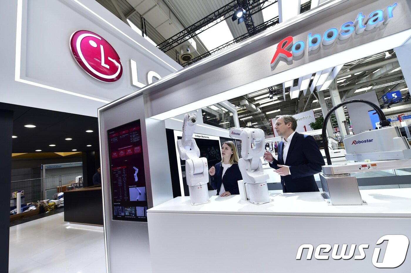 본문 이미지 - LG전자 부스를 방문한 관람객들이 로보스타의 수평다관절 로봇과 수직다관절 로봇을  살펴보고 있다. LG전자는 로보스타의 경영권을 인수한 최대주주다.(LG전자 제공)ⓒ 뉴스1