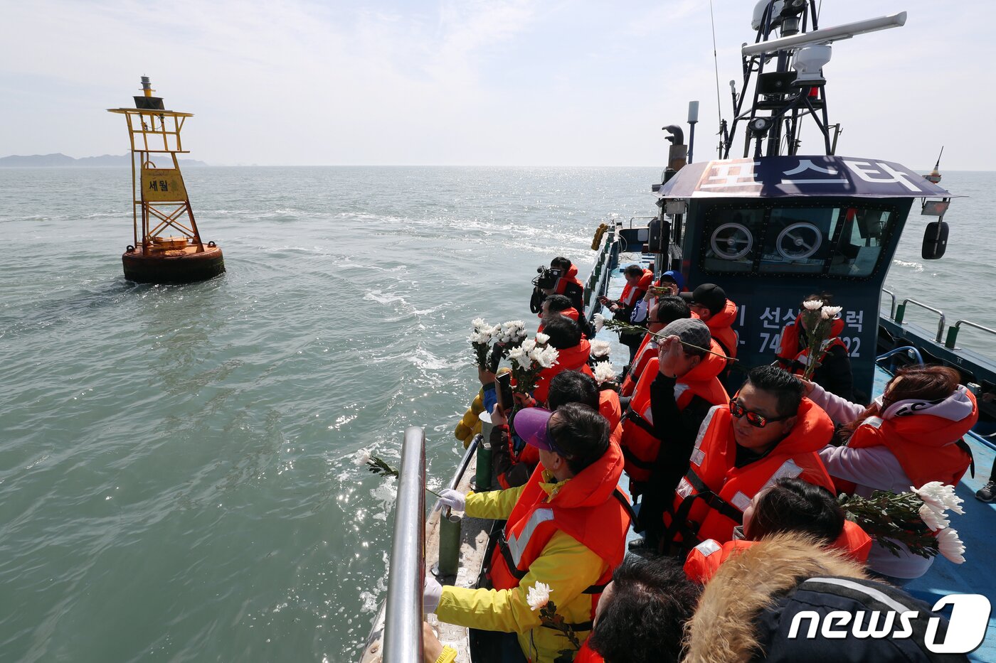 본문 이미지 - 세월호 참사 5주기인 16일 오전 전남 진도군 동거차도 앞 세월호 침몰 해역에서 단원고 유가족들이 헌화를 하기 앞서 사고해역을 표시하는 부표를 바라보고 있다. 2019.4.16/뉴스1 ⓒ News1 황희규 기자