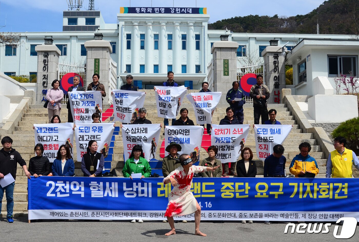 본문 이미지 - 춘천시민사회단체네트워크를 비롯한 시민단체가 16일 오전 강원도청 광장에서 열린 ‘2천억 혈세 낭비 레고랜드 중단 요구 기자회견’에서 준비한 퍼포먼스를 선보이고 있다. 2019.4.16/뉴스1 ⓒ News1 하중천 기자