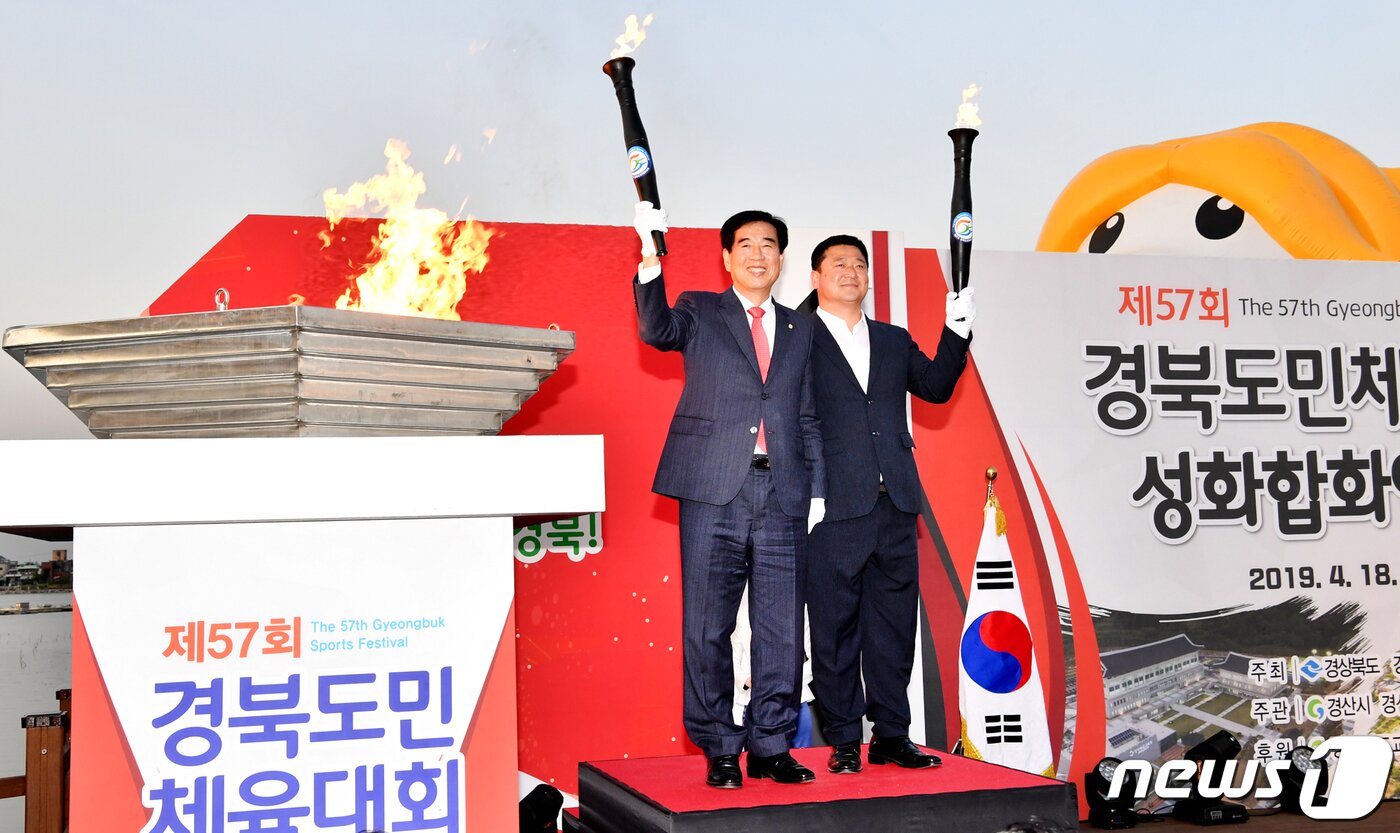 본문 이미지 - 18일 오후 경산시 남매지 특설무대에서 열린 도민체전 성화 합화 안치식에서 최영조 경산시장(왼쪽)과 강수영 시의장이 합화를 하기위해 성화를 들고 있다.경산 도민체전은 오는 19일부터 나흘간 경산시민운동장에서 펼쳐진다(경산시제공)2019.4.18/뉴스1 ⓒ News1 정우용 기자