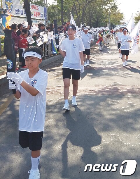 본문 이미지 - 18일 열린 제57회 경북도민체전 성화 봉송행사에서 용성초등학교 학생이 성화를 봉송하고 있다. 봉송된 성화는 남매지 특설무대에서 합화·안치식을 가졌다. 경산 도민체전은 오는 19일부터 나흘간 경산시민운동장에서 펼쳐진다(경산시제공)2019.4.18/뉴스1 ⓒ News1 정우용 기자