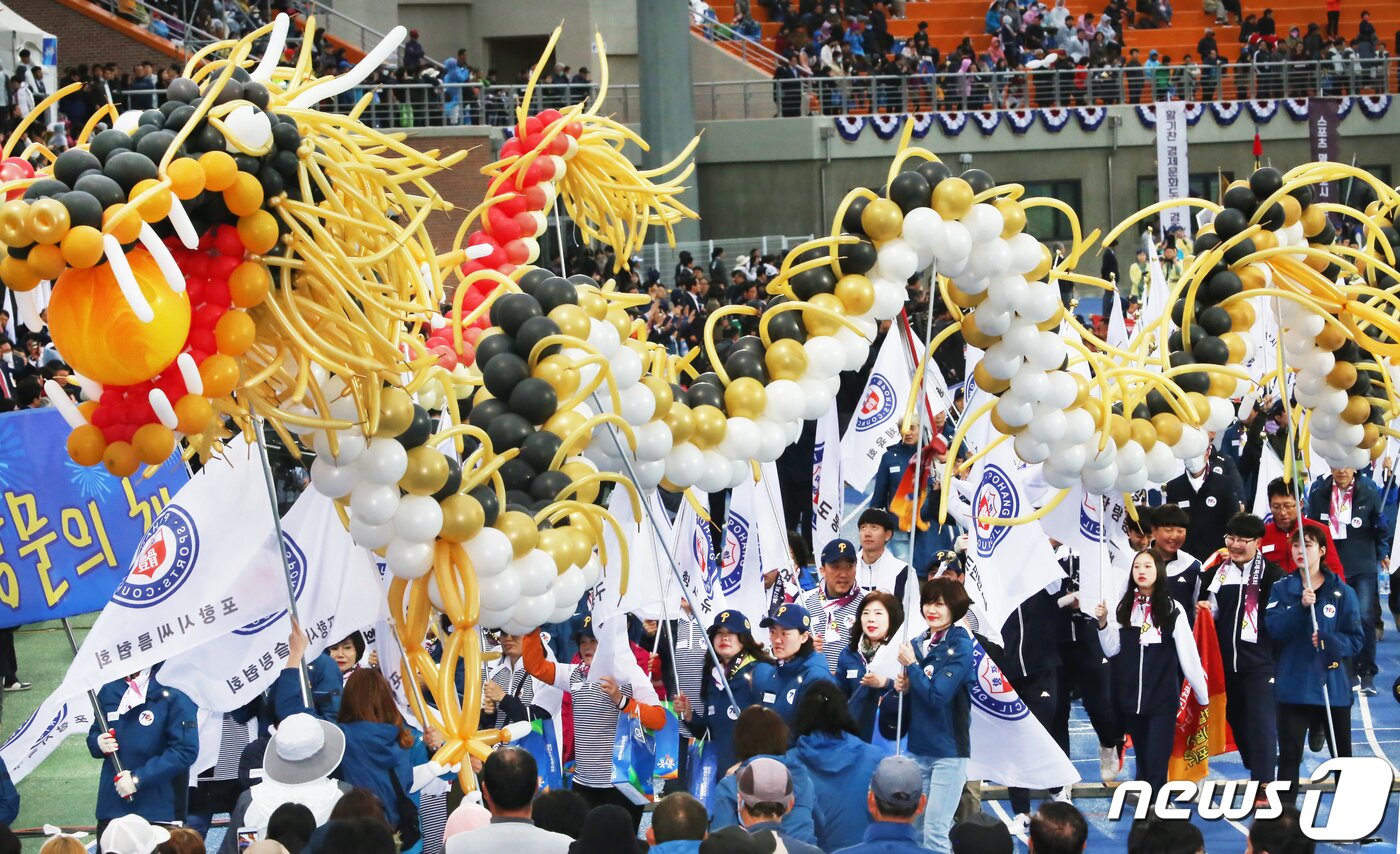 본문 이미지 - 19일 경북 경산시민운동장에서 열린 제57회 경북도민체육대회 개회식에 참여한 23개 시·군 선수단이 다양한 퍼포먼스와 함께 입장하고 있다. ‘희망도시 경산에서 하나되는 경북의 힘!’이라는 슬로건 아래 오는 22일까지 나흘간 열전에 돌입하는 이번 도민체전에는 경북도내 23개 시·군 1만2000여 명의 선수단(선수 8600명·임원 3500명)이 육상, 테니스, 레슬링 등 총 26개 종목에 출전해 고장의 명예를 걸고 열띤 경쟁을 펼친다. 2019.4.19/뉴스1 ⓒ News1 정우용 기자