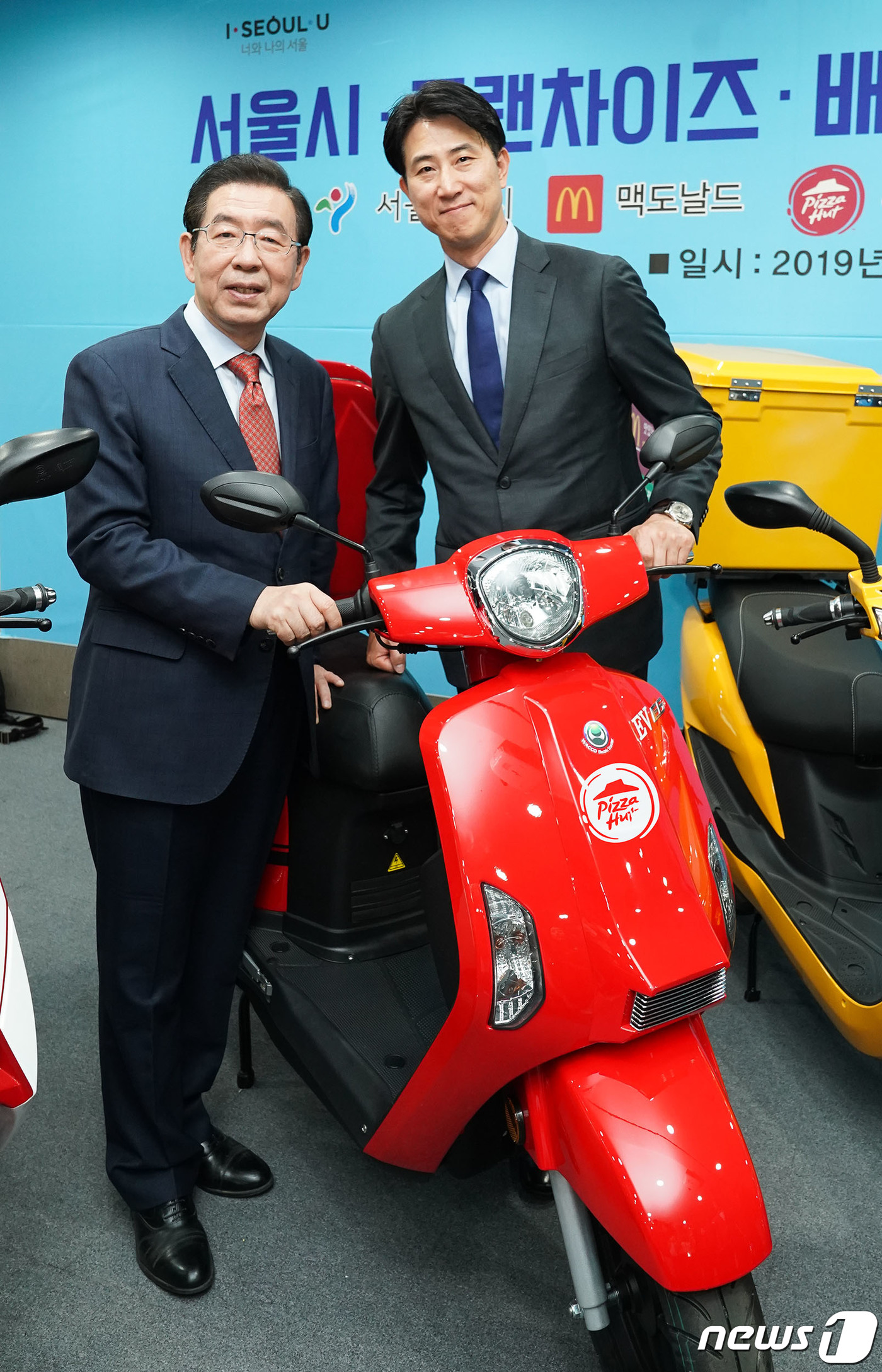 (서울=뉴스1) = 유지영 한국피자헛 이사(왼쪽)와 박원순 서울시장이 24일 오전 서울시청 영상회의실에서 열린 '전기 이륜차 전환 업무협약식'에서 배달용 이륜차 앞에서 기념촬영을 …