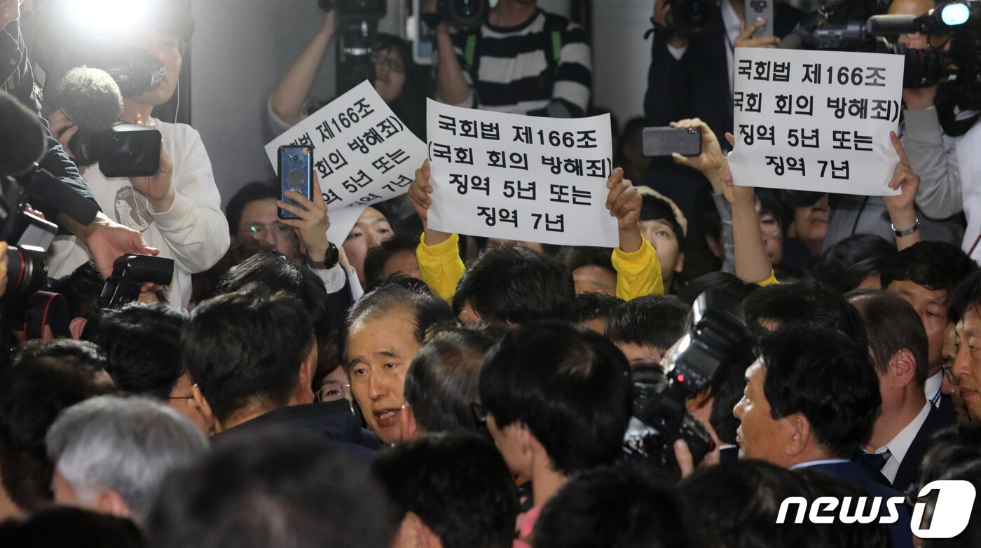 본문 이미지 - 26일 오후 서울 여의도 국회 정치개혁 특별위원회 전체회의장 앞에서 자유한국당 의원 및 당직자들이 공직선거법 개정안 신속처리안건(패스트트랙) 지정동의의 건 통과를 막기 위해 입구를 막아서자 정의당, 민주당 의원 및 당직자들이 '국회법 제166조(국회 회의 방해죄) 징역 5년 또는 징역 7년'이라고 쓰인 손팻말을 들고 있다. 2019.4.26/뉴스1 ⓒ News1 안은나 기자