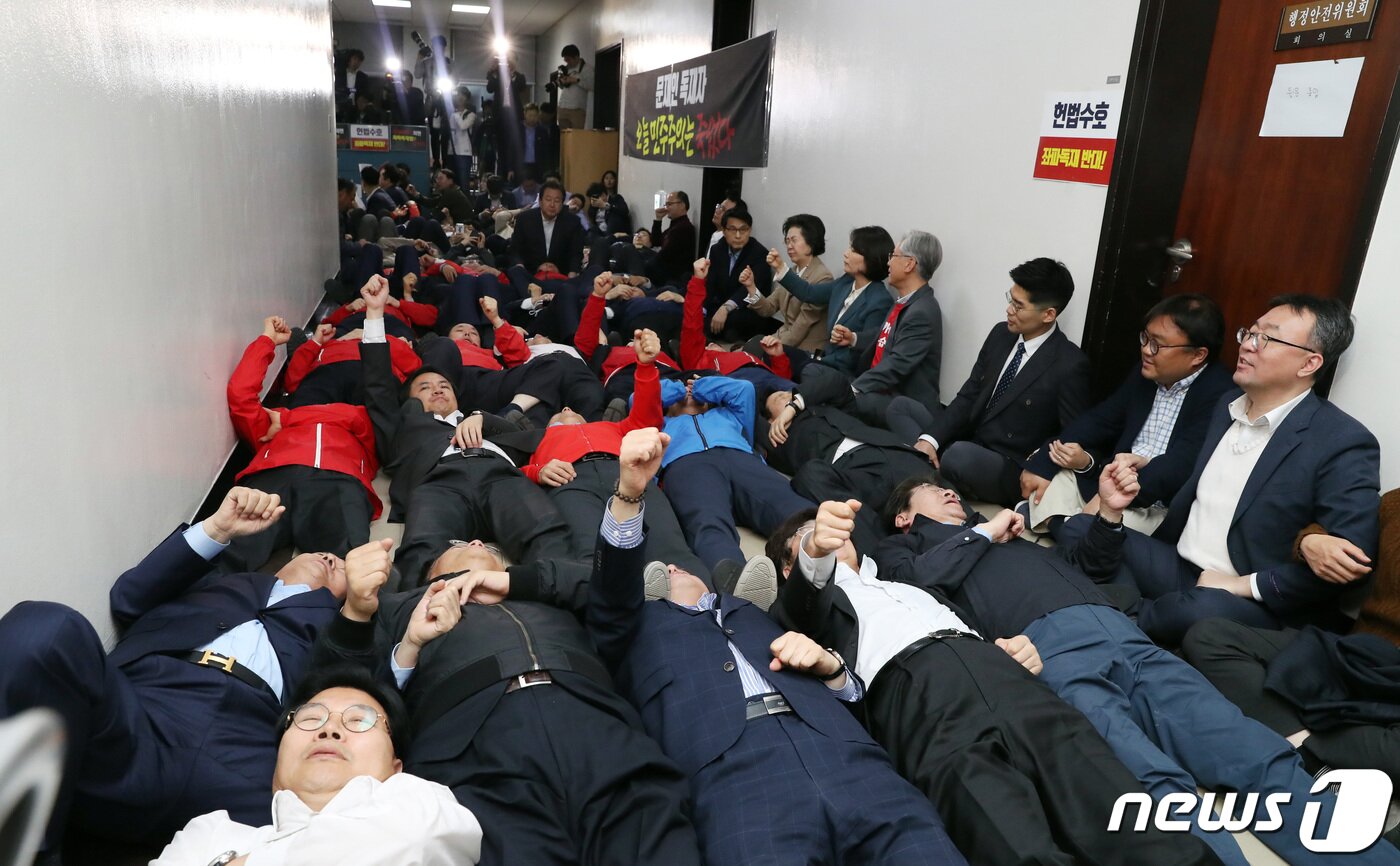 본문 이미지 - 자유한국당 의원들이 29일 오후 선거제도 개혁 패스트트랙 지정을 위한 정치개혁특별위원회 전체회의가 열릴것으로 예상되는 서울 여의도 국회 행안위 회의실 앞에서 패스트트랙 저지를 위해 점거한 후 구호를 외치고 있다. 2019.4.29/뉴스1 ⓒ News1 김명섭 기자