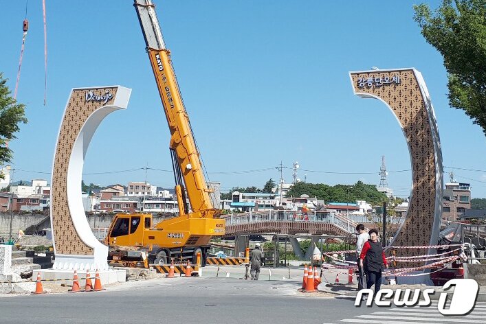 본문 이미지 - 지난 21일 천년의 역사를 자랑하는 유네스코 인류무형문화유산 강릉단오제 개막을 앞두고 강원도 강릉시 남대천 축제장 입구에 상설 단오 문 설치 작업이 진행 중이다. 단오 문은 그동안 축제 기간에 맞춰 조립과 해체를 반복했으나 올해부터 문화개발 사업의 하나로 상설하게 됐다. 2019.5.22/뉴스1 ⓒ News1 서근영 기자